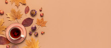 Autumn Flat Lay Composition. Cup Of Tea, Autumn Dry Bright Leaves, Roses Flowers, Orange Circle, Cones, Decorative Pomegranate, Cinnamon Sticks On Brown Beige Background Top View. Autumn, Fall Concept