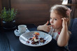 © Liliya Rodnikova/Stocksy - Cute little girl eating dessert at cafe