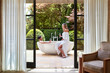 © Trinette Reed/Stocksy - Couple in outdoor bathtub at luxury resort drinking Ros? wine