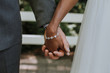 © Leah Flores/Stocksy - Wedding Bride and Groom Holding Hands