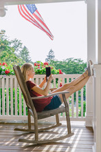 Teen On Tablet Relaxing On Porch