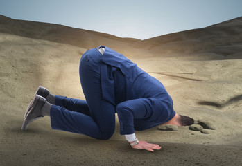 Wall Mural - Businessman hiding his head in sand escaping from problems