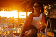 © MEM Studio/Stocksy - Young woman in sunglasses relaxing on chair during sunset