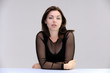 © Вячеслав Чичаев - Portrait of a pretty beautiful fashionable adult girl with beautiful brunette hair in a black dress. Sits at the table directly in front of camera, talking demonstrating different poses and emotions