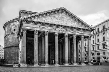 Black and white image of the facade of the Pantheon with no people. The Pantheon is a former Roman temple that's now a church in the ancient capital city of Rome, Italy, Europe