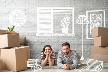 Wall Mural - Happy couple with belongings imagining interior of new house