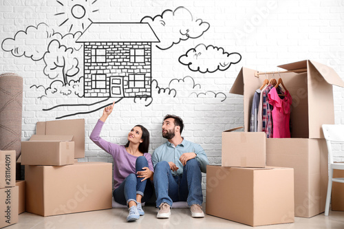 Fotografía Young couple with belongings dreaming about moving into new house