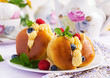 Rum baba decorated with whipped cream and fresh raspberry, blueberry. Savarin with rum, cream and berries. Italian cuisine