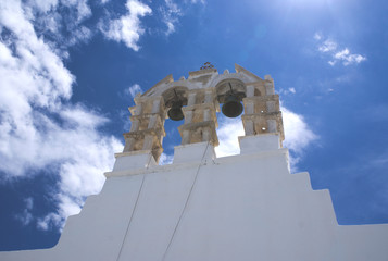 Greece, the island of Paros. The bell tower of a church in the resort town of Naoussa.  A sunny day with light cloud.