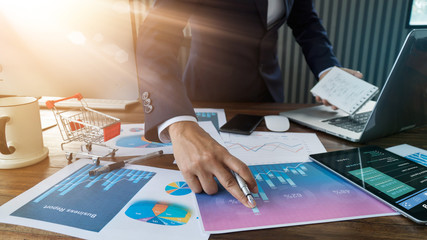 Poster - Businessman analyzing sales data and economic growth and    pointing at business report document with graph chart financial diagram, marketing, banking and payments, business planning and strategy.