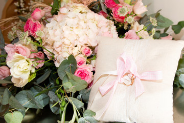 Background with wedding rings in light tone on cushion marriage