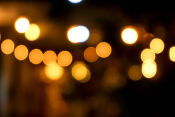 abstract blurred and bokeh light bubs reflection lighting of small pub in the city at the night time