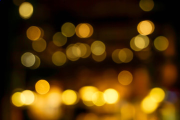 Wall Mural - Abstract blurred and bokeh light bubs reflection lighting of small pub in the city at the night time.