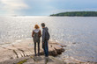 © Tatyana_Andreyeva - Middle aged man and young lady walking on northern lake shore in summer day. Tourists against picturesque landscape. Travelling and discovering distant places of Earth. Onega lake, Karelia, Russia