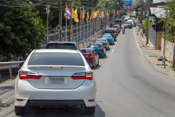 Naklejka na meble A convoy of cars beside a Buddhist temple on the feast day - Queen Suthida’s Birthday Anniversary, Thailand.
