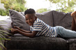© wavebreak3 - Boy using digital tablet on a sofa in living room at home