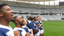 Group Of Diverse Male Rugby Players Taking Pledge Together In Stadium