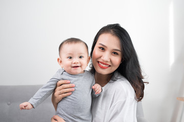 happy family at home. Mother holding baby daughter in living room in cozy weekend morning