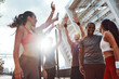 © gstockstudio - Group of young people in sports clothing giving each other high five and smiling while exercising outdoors