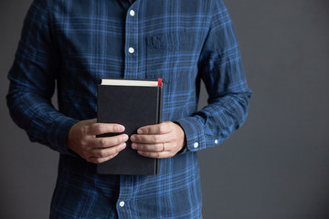 Wall Mural - Man is holding and hug the bible in the morning. Hands folded in prayer on a Holy Bible in life concept. worship and religion. copy space