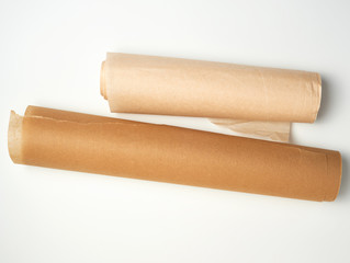 two rolls of brown parchment paper for baking on a white background