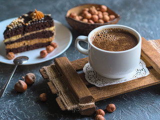 Breakfast. Coffee morning , with a slice of cake and hazelnuts on a textural background.