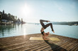 © Westend61 - Woman practicing yoga on jetty at lake
