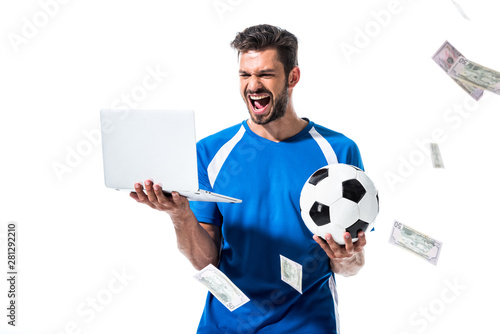 Fotomural cheering soccer player with ball and laptop near falling money Isolated On White