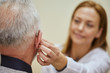 © Westend61 - Female doctor applying hearing aid to senior man's ear