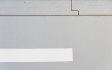 A gray wall of concrete and a white strip