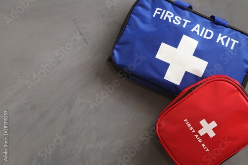 What first aid kit should you have? Blue and red first aid kits on grey background.