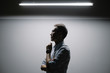 © JIACHUAN LIU/Stocksy - Side view of businessman standing under light