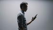 © JIACHUAN LIU/Stocksy - business man using a phone under light