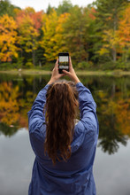Woman's Hands Holding Phone And Photographing A Beautiful Forest In Fall.