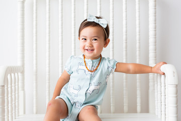 Toddler Girl Sitting on Bench Smiling