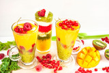 Fototapeta Kuchnia - Wielowarstwowe smoothie z mango, kiwi, selera naciowego, malin, porzeczek, banana, jarmużu i kremu waniliowego