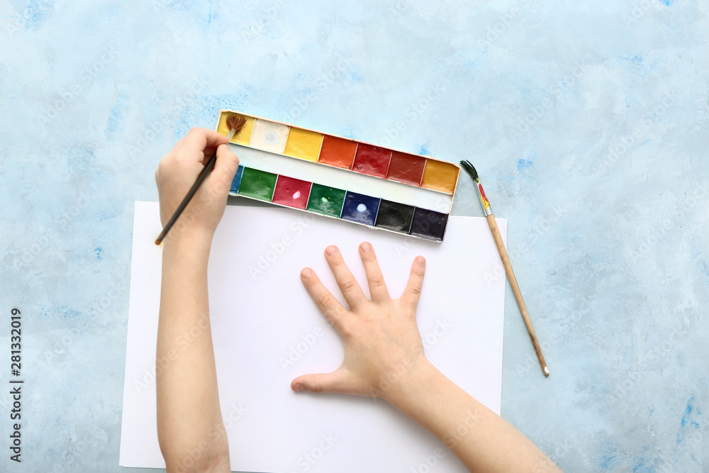 Cute little girl painting at table, top view