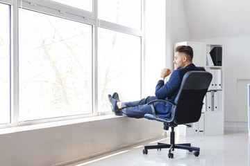 Canvas Print - Carefree businessman having break in office