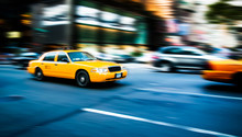 Yellow Cab Taxi Traditional Of New York City In Fast Movement With Motion Blur Panning, In The Busy Streets Of Manhattan, Accelerating Traffic Moves During Evening.