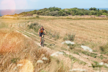 Wall Mural - pretty young woman doing mountain bike in the summer sun