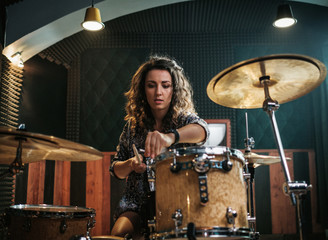 Wall Mural - Woman playing drums during music band rehearsal