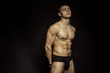 © Oleh Phoenix - Strong stripped muscle male model in underwear on black isolated font background