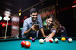© NDABCREATIVITY - Couple drinking beer and playing snooker on date