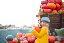 Happy Little Girl At The Autumn Pumpkin Patch Background. Having Fun. Toned In Retro Style