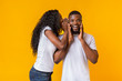Black girl whispering gossips to his boyfriend
