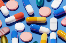 Various Pills And Medicine On A Blue Background. Close Up 3D Render Illustration.