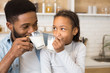 © Prostock-studio - Black girl and her father drinking fresh milk