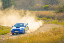 Blue Rally Car Passes Turn Of The Road
