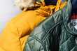 In the closet of the house hang new warm jackets - down jackets, preparing for the autumn..