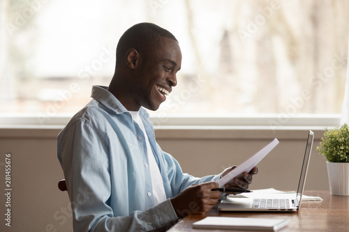 Fotomural African guy sit at table read documents feels happy